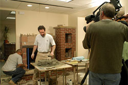 Masonry apprentice Jason Brooks and mason Chris Olgierson are filmed by cameraman Kirk Selby of High Noon Entertainment as they build a fireplace in the conference room of Rocky Mountain Masonry Institute. Brooks was selected for a segment on 