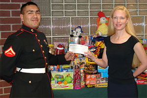 U.S. Marine Corps Lance Corporal Mario Ornelas receives a $1,000 donation for Toys for Tots from Rocky Mountain Masonry Institute Executive Director Larisa LaBrant.