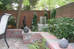 The brick walls provide a surface for capturing and reflecting the gentle sounds from a small fountain in one of the planters.