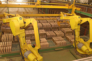 In Hanson Brick's fully computerized Monroe 3 brick plant, computerized robot arms unload green bricks from a conveyor belt and place them on the kiln car for drying and firing. Photo Courtesy of Hanson Brick.