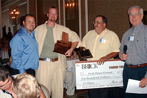 Outgoing 2006 winner Tony Woodson and contest organizers Steve Williams and Bryan Light present first-place, third-year contest winner Sam Huhn (second from left) with his award.