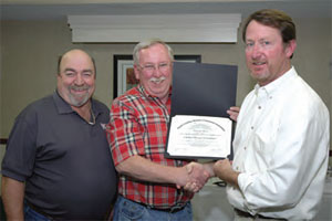 Pictured are Doug Burton, NCMCA certification board of governors chairman (right), who presents Wayne Starr, NCMCA president, (middle) with the first certificate awarded from the program, as NCMCA VP Larry Kirby, also among the first graduates, looks on.