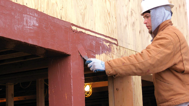 A technician demonstrates the ease of detailing rough openings with the “new breed” of air and water barrier products. Just gun it on and spread it out – no complicated tapes, fabrics or peel-and-stick membranes.