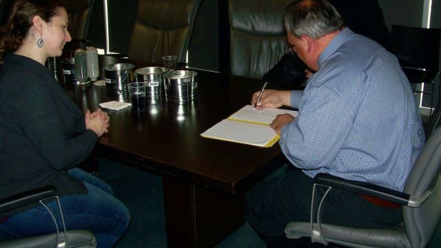 John Dale, plant manager for Ash Grove Cement Louisville manager, and Laura Stastny, executive director of Nebraska Wildlife Rehab Inc. (NWRI), met to sign an agreement extending the use of an on-site Ash Grove building to NWRI.