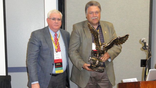 MCAA Chairman John Smith (left) presents Mackie Bounds (right) with the C. DeWitt Brown Leadman Award