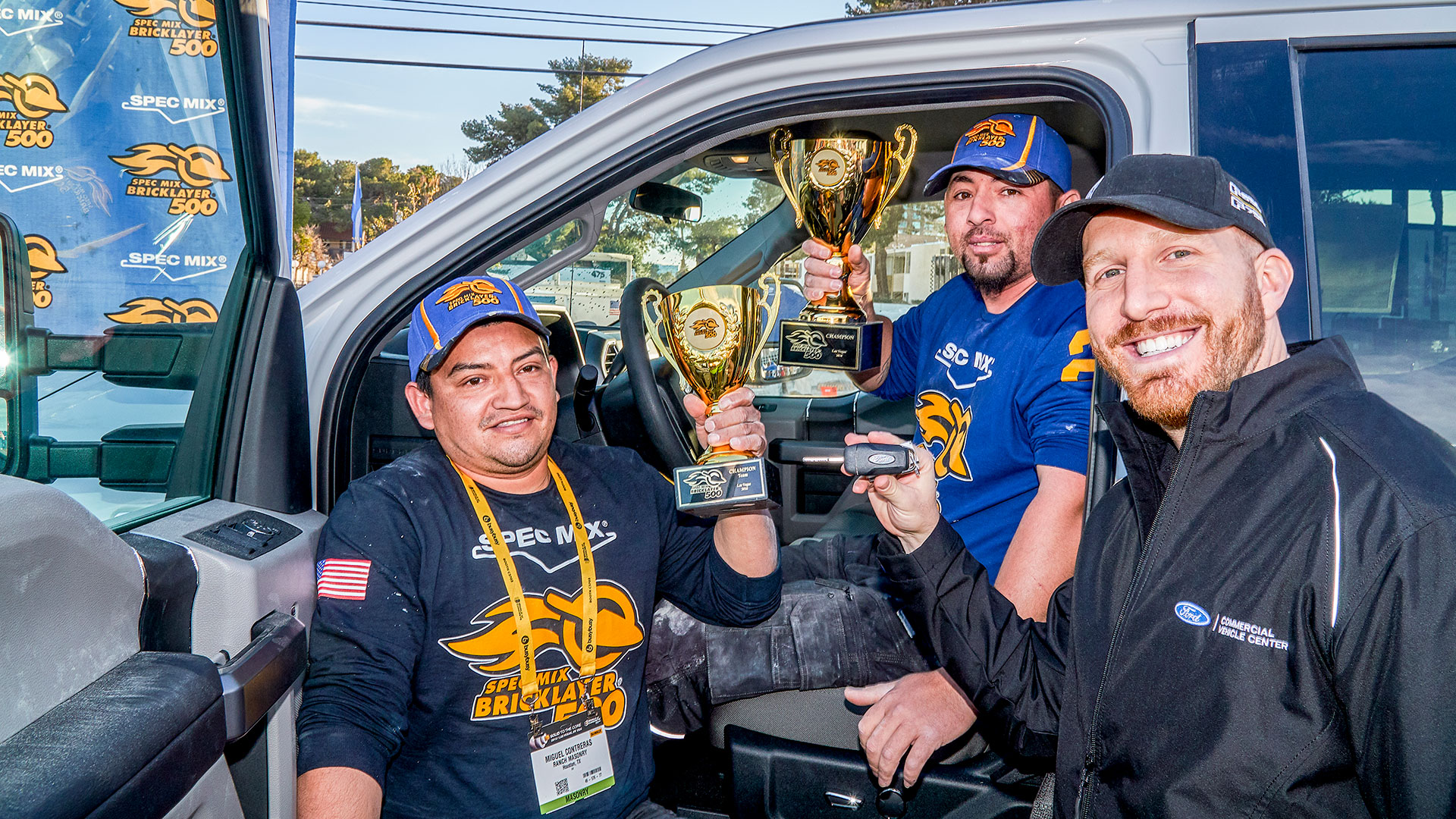 Cory Belonzi (right) with Ford Commercial Vehicles hands over the keys to a 2018 Ford F-250 Super Duty Truck to World Champion David Chavez (middle) as he holds up the SPEC MIX BRICKLAYER 500® World Championship ceremonial trophy.
