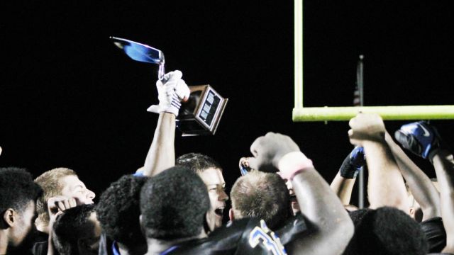 The Menendez High School football team celebrates with the Golden Trowel Trophy