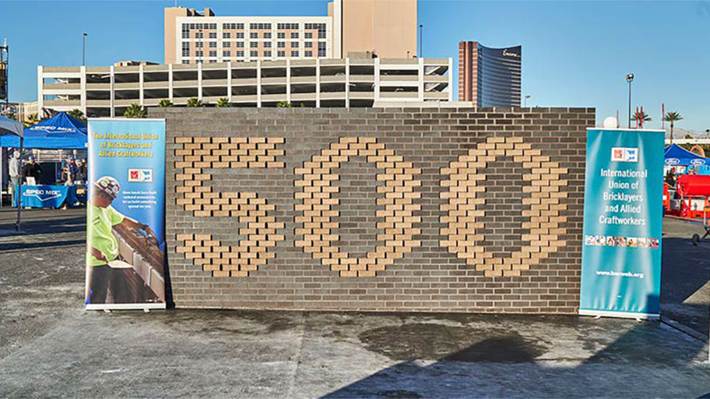 A raised brick wall tribute to the SPEC MIX BRICKLAYER 500 built by International Union of Bricklayers and Allied Craftworkers in the Innovation & Workforce Development Zone.