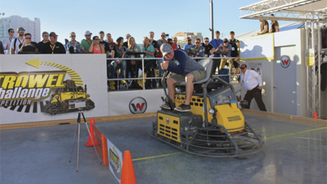 Crowds watch the 2015 Trowel Challenge winner, Greg Geiger, owner of On Demand Concrete, Warburg, Alberta Canada as he concentrates while crossing the finish line!