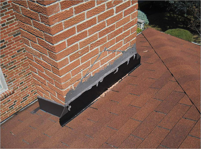 Cricket or saddle has been removed from this masonry chimney wider than 30 inches.