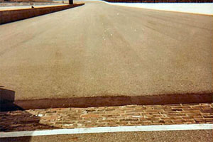 It is interesting to note that the Indianapolis Motor Speedway was surfaced with more than 3 million clay pavers before it was covered with asphalt. The original pavers still stand at the start/finish line of the track as shown.