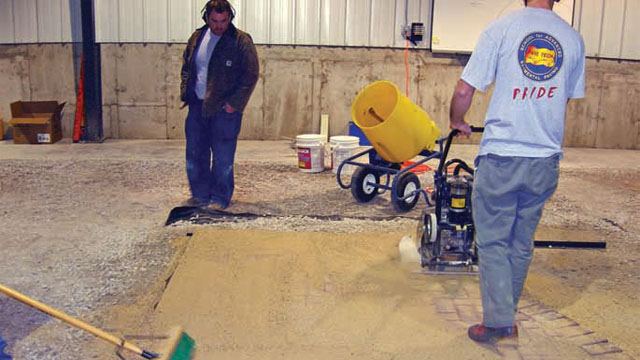 Masons are being trained to install pavers in a patio.