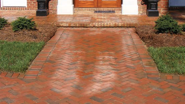 A home featuring a walkway of permeable pavers.