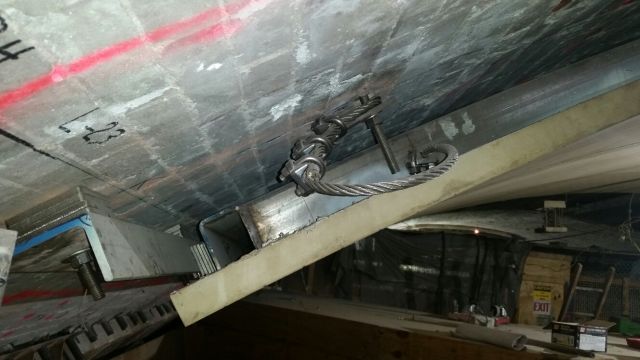 The ceiling panel attachment at the side wall and an additional anchor in the center edge of the panel attachment to the ceiling.