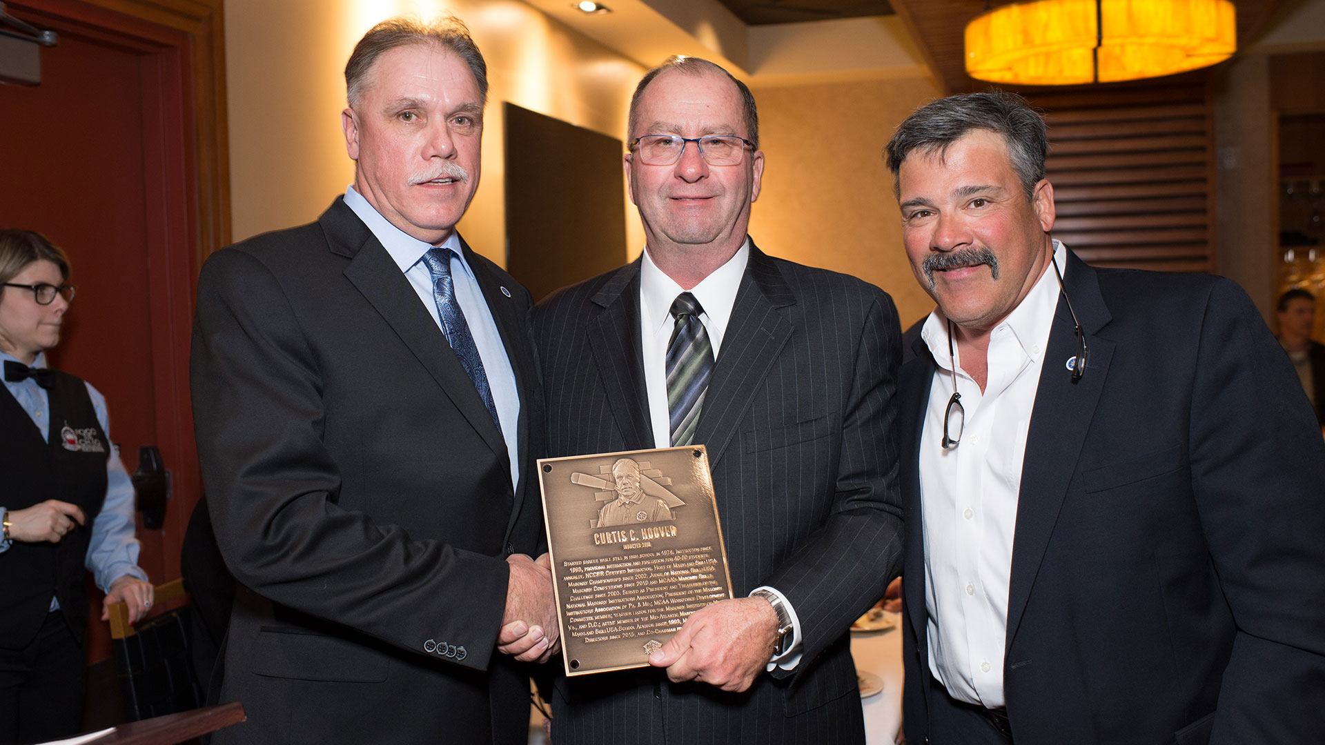 MCAA Chairman Mike Sutter (center) presents Curtis Hoover  (left) with his Masonry Hall of Fame plaque.