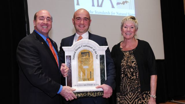 Stefano Follega (center) accepts the 2014 Craftsman of the Year Award from MIA President Tony Malisani and program sponsor Brenda Edwards of TexaStone Quarries