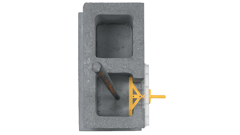 A T-bolt holds the plastic window flush with the face of the wall. After the pour, the window is removed, and the T-bolt is snapped off.