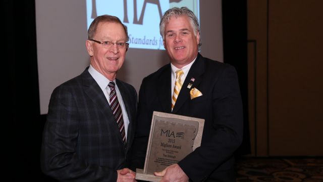 om Schlough receives the Migliore Award for Lifetime Achievement from 2015 MIA President, Dan Rea (Coldspring). 