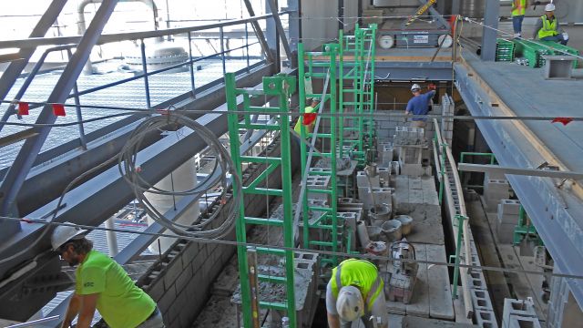 Photo 1: Seedorff Masonry used Non-Stop scaffolding in a 90-foot-high elevator shaft. The masons outriggers and Inside Corner Arms were used to fully plank the inside of the shaft.