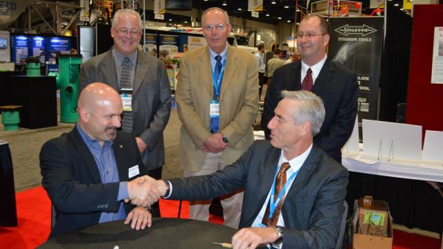 Tom Cindric (left) and Mark Kemp (right) sign an extension for the MCAA Convention to remain at World of Concrete